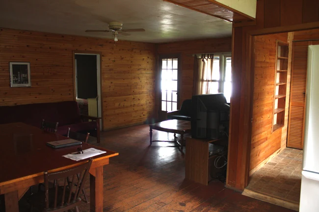 Pigeon Lake Resort Cottage Two.&nbsp; Open concept cottage interior with dining area, living room, and wood-paneled walls.